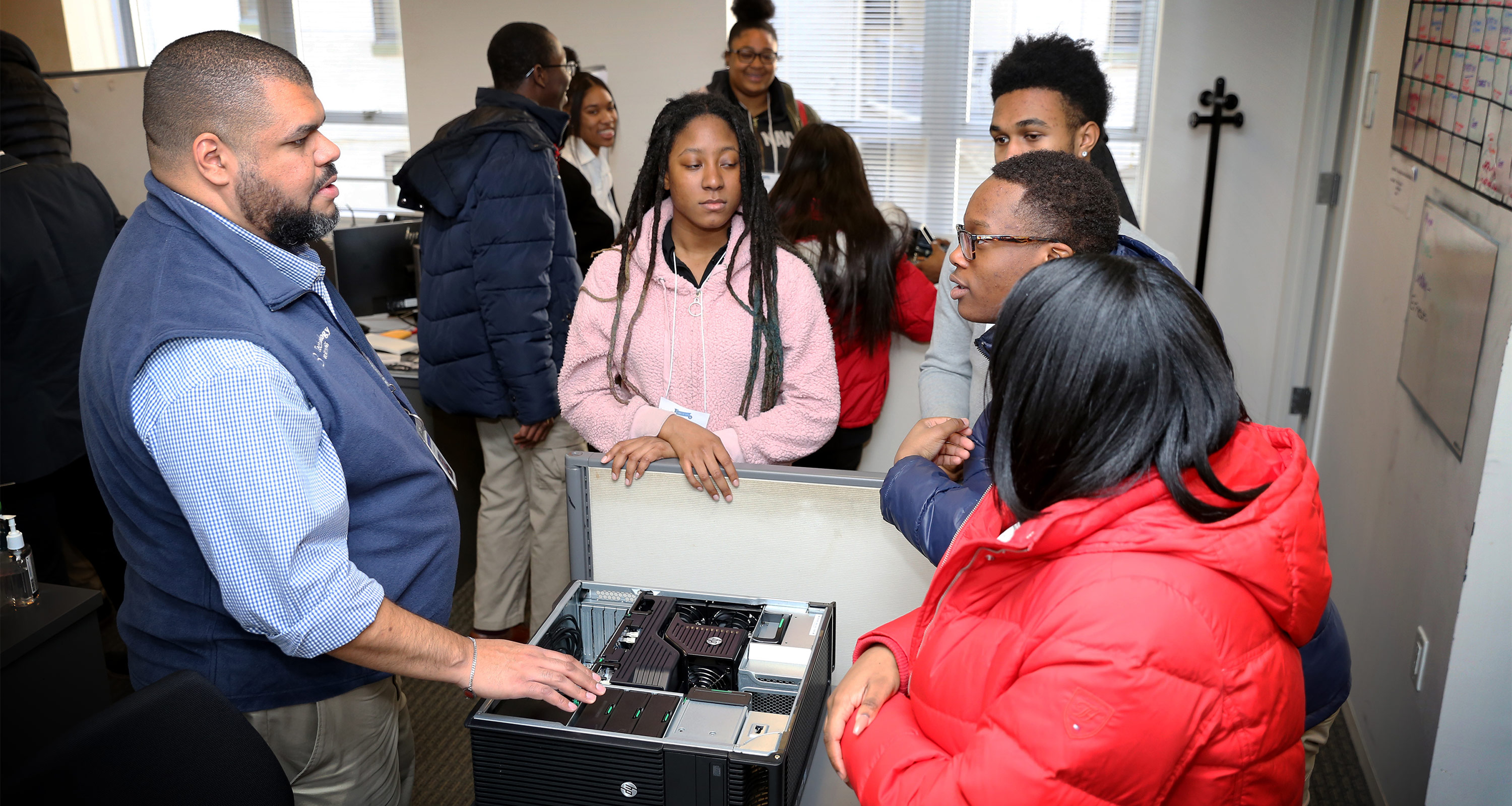 Students from local high schools talking with a Brookings employee about how a computer runs. Copyright 2019 Sharon Farmer Photography.